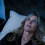 person lying awake in bed at night unable to sleep , looking at the clock 3am