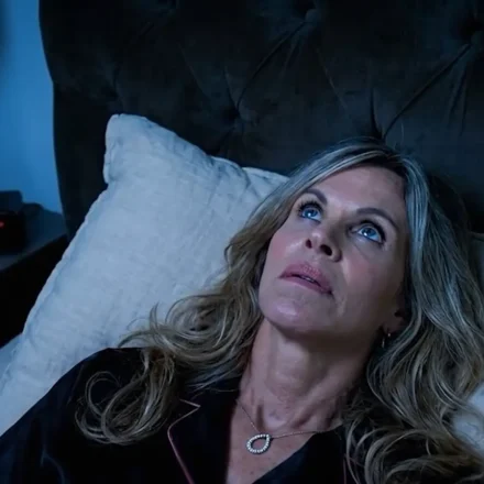 person lying awake in bed at night unable to sleep , looking at the clock 3am